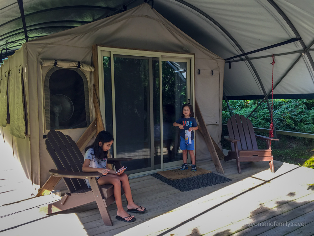 Kids at the front door of a safari glamping tent at Long Point Eco Adventures