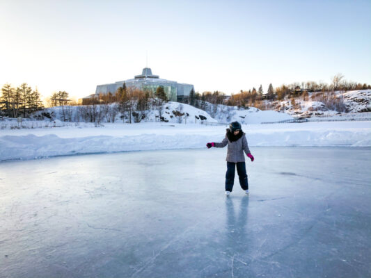 Girl skating on Ramsey Lake in front of Science North in Sudbury.