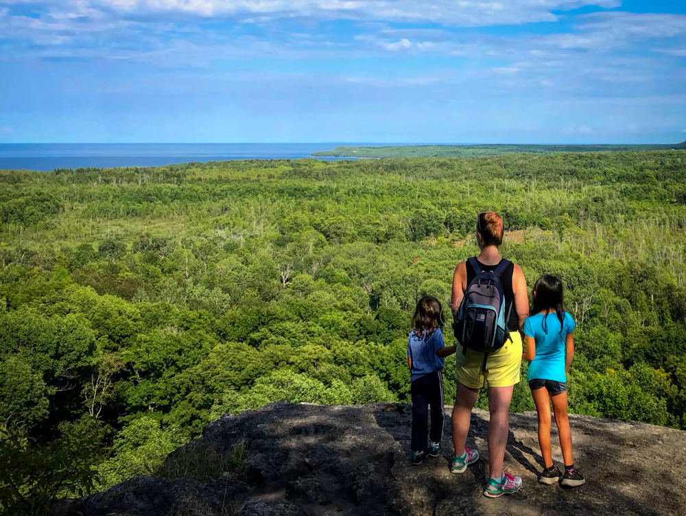Mother and two children on look out point at Skinner's Bluff on the Bruce Peninsula. One of the best hiking trails in Southern Ontario
