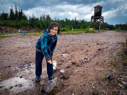 Child in foreground digging for amethyst at Amethyst Mine Panorama with the field behind them